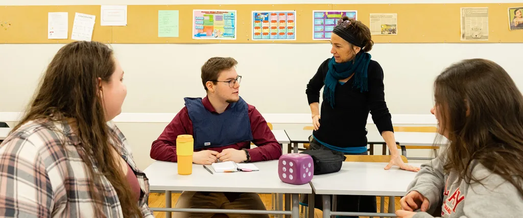 Enseignante qui explique au bureau d'un étudiant