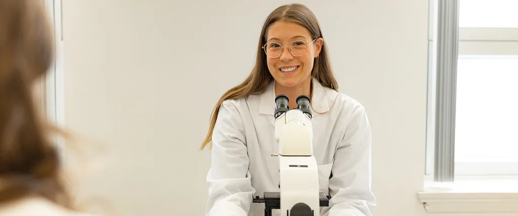 Étudiante derrière un miscroscope