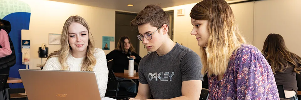 3 étudiants à un ordinateur portable